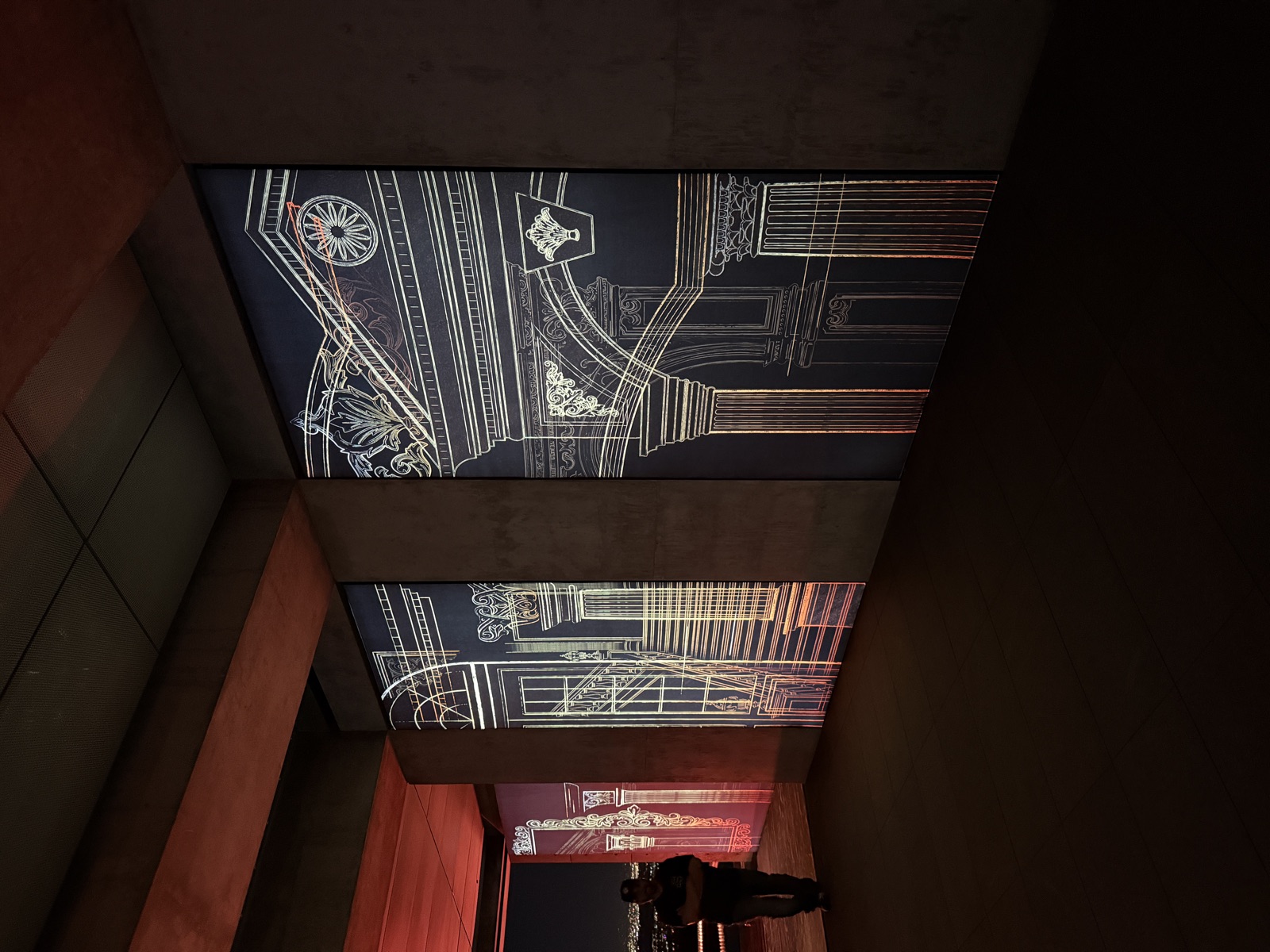 Ornate architectural line-art projections on ceiling panels