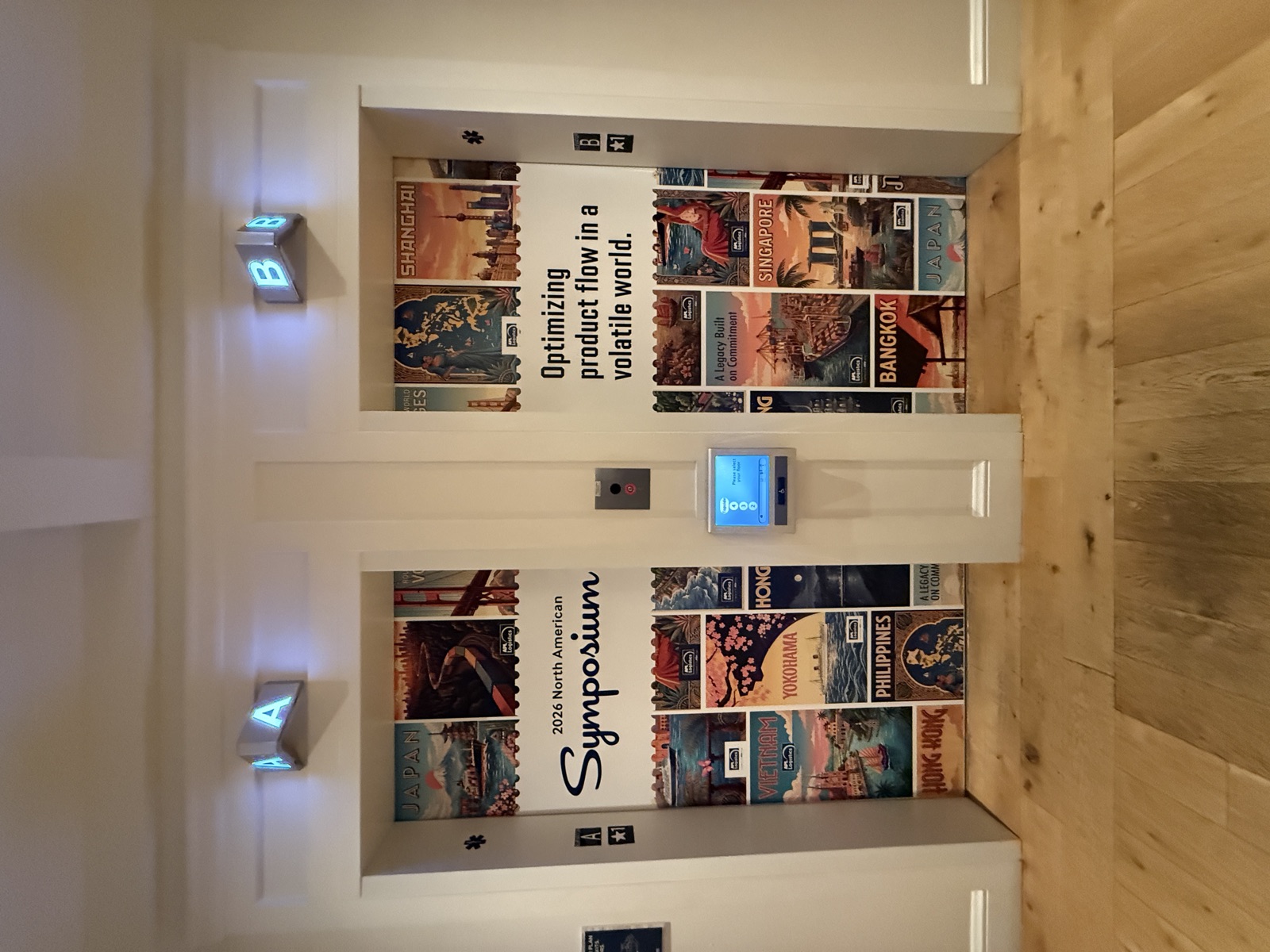 Symposium branded elevator door wraps with travel poster graphics