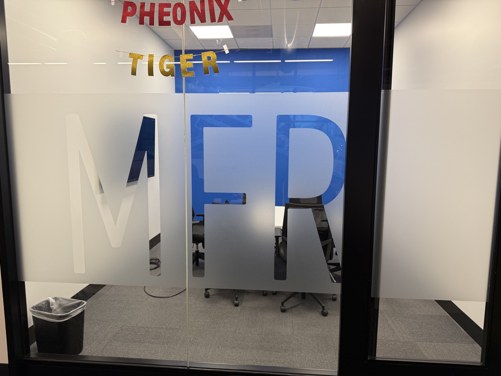 Conference room with frosted glass and large airport code typography