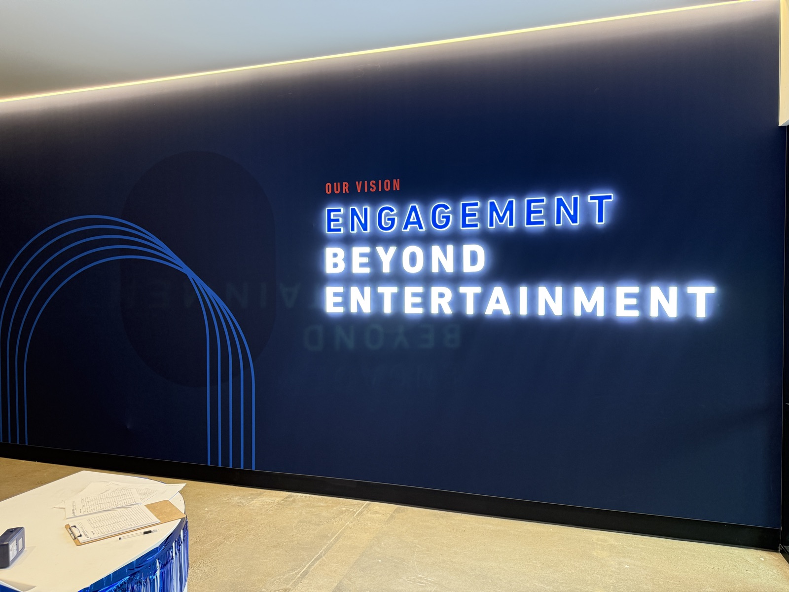 Panasonic Portland office illuminated engagement wall with dimensional lettering against navy accent wall