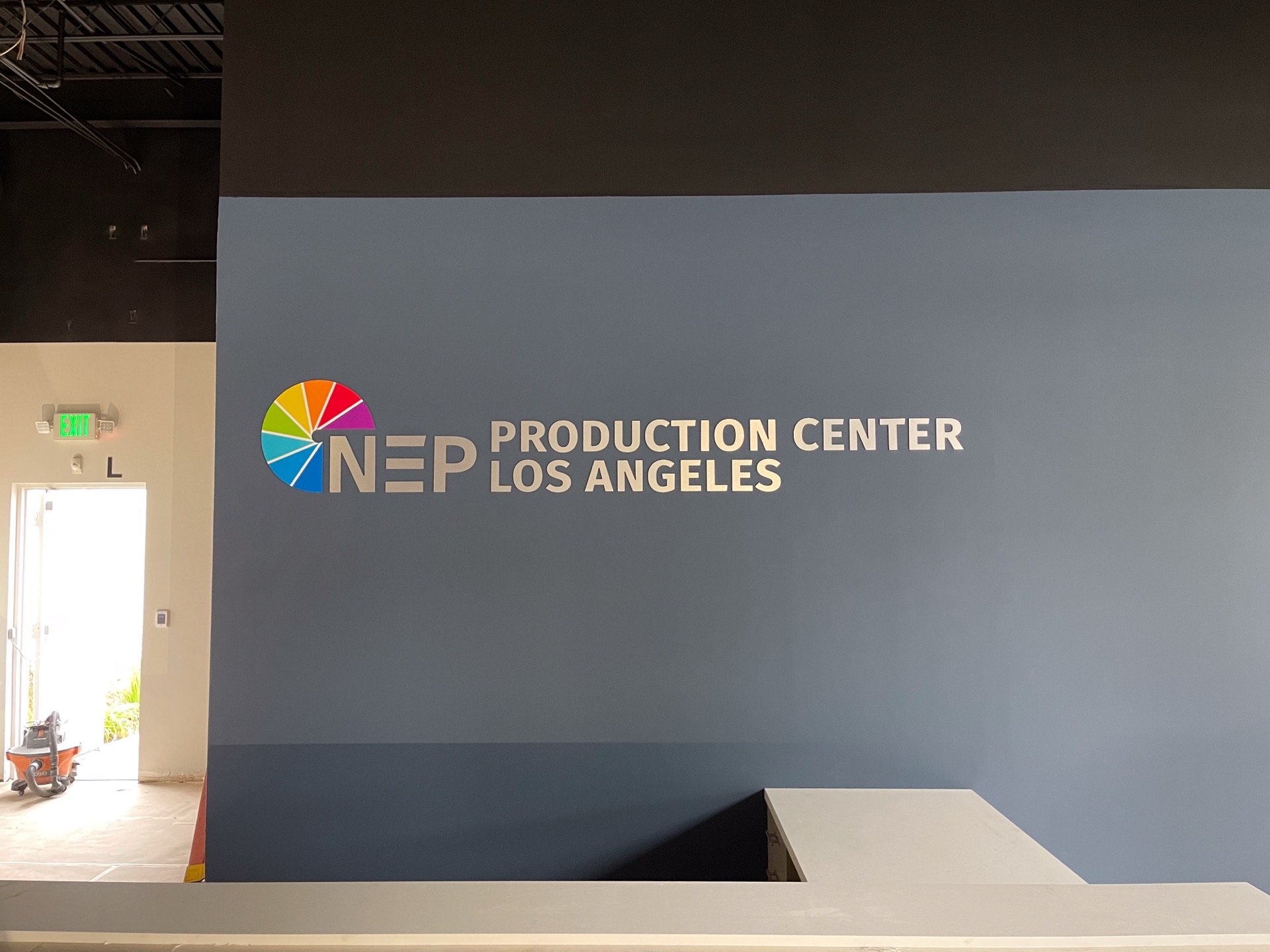 NEP production center lobby with dimensional signage and pin-set logo